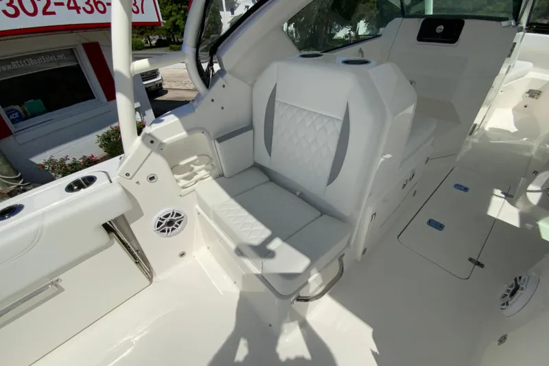 Slide: The Image of 2026 Pursuit DC 266 Dual Console boat interior with white seating and cup holders. - 18