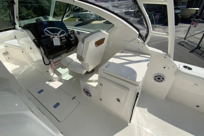 Slide: The Image of 2026 Pursuit DC 266 Dual Console boat interior with helm, seating, and storage compartments. - 20