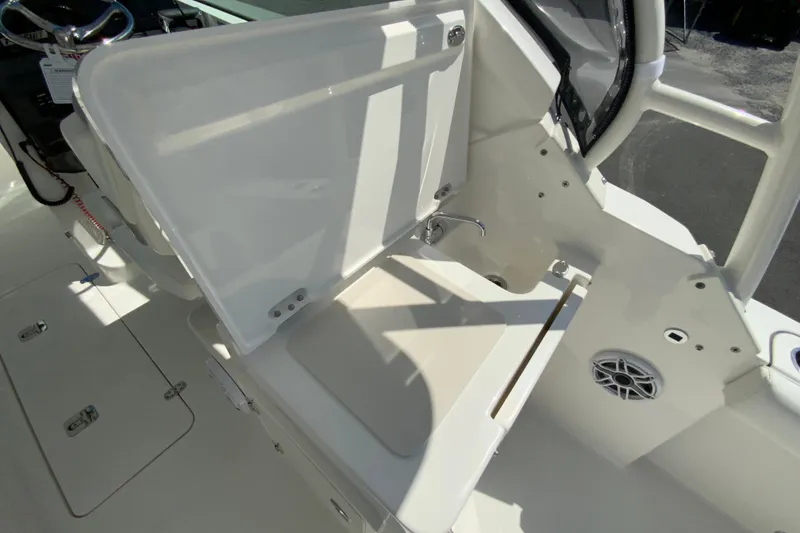 Slide: The Image of 2026 Pursuit DC 266 Dual Console interior with open storage compartment and speaker. - 21