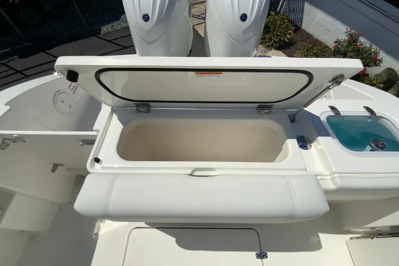 Slide: The Image of 2026 Pursuit DC 266 Dual Console boat with open storage compartment and seating. - 24