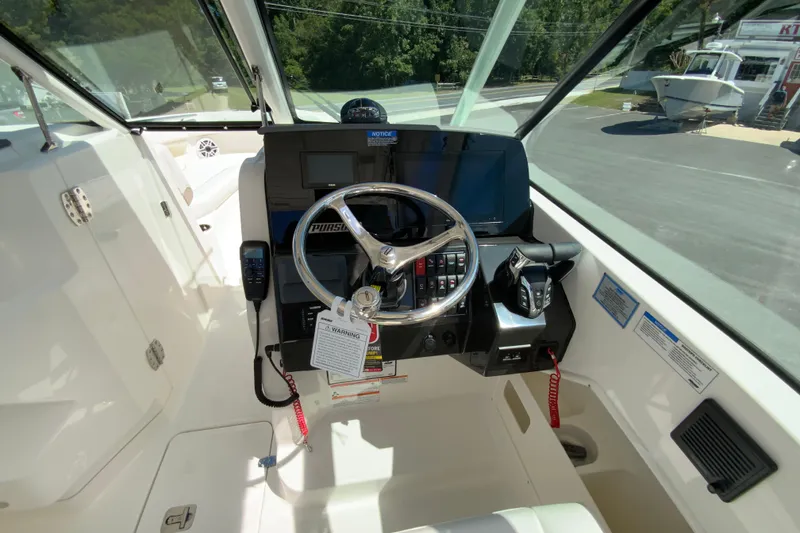 Slide: The Image of 2026 Pursuit DC 266 Dual Console boat cockpit with steering wheel and control panel. - 28