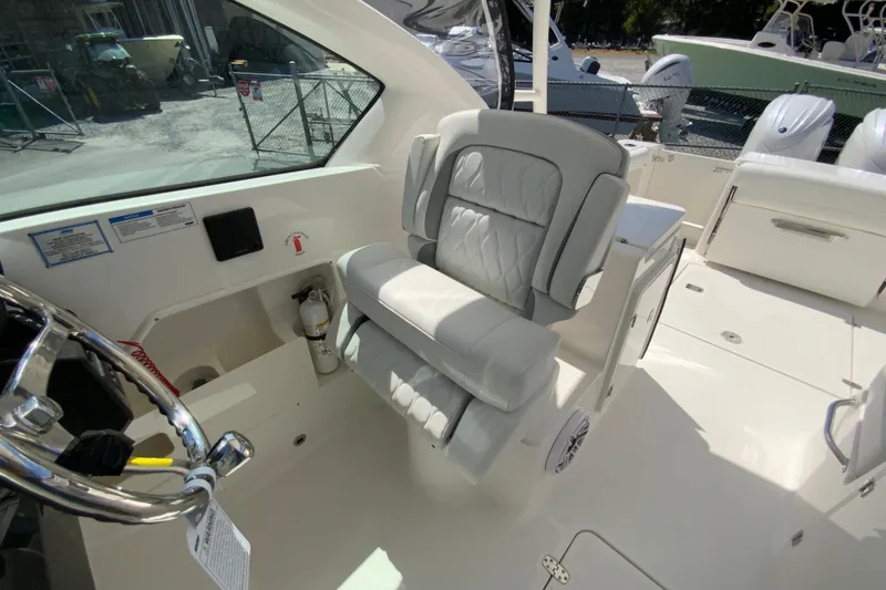 Slide: The Image of 2026 Pursuit DC 266 Dual Console boat interior with luxurious seating and steering wheel. - 31