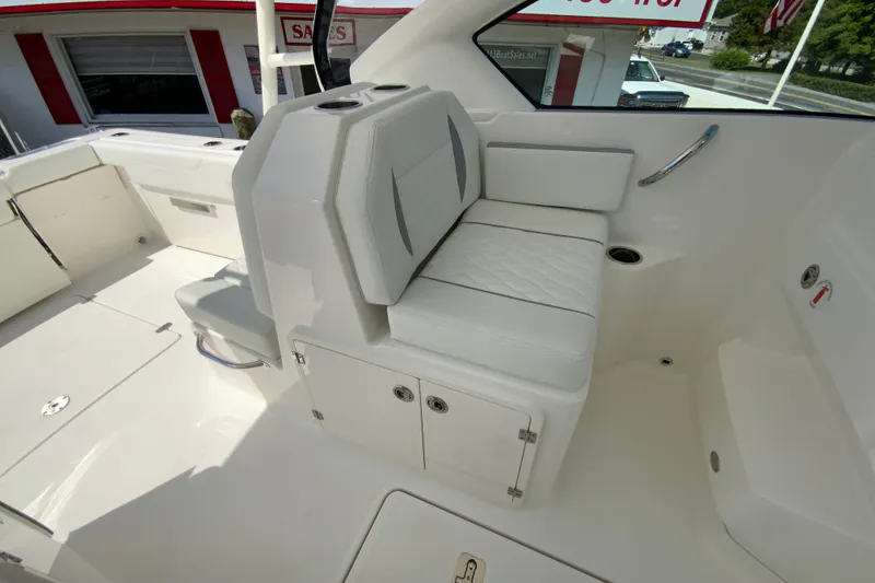 Slide: The Image of 2026 Pursuit DC 266 Dual Console boat interior with white seating and storage compartments. - 32