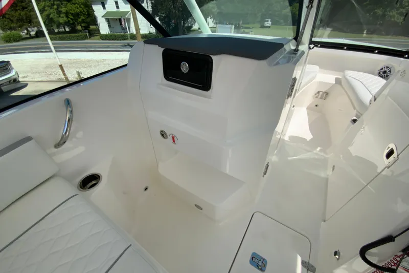 Slide: The Image of 2026 Pursuit DC 266 Dual Console interior with white seating and storage compartments. - 34