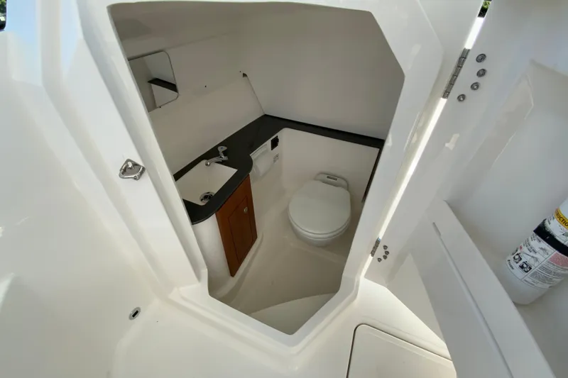 Slide: The Image of 2026 Pursuit DC 266 Dual Console boat interior with compact bathroom amenities. - 35
