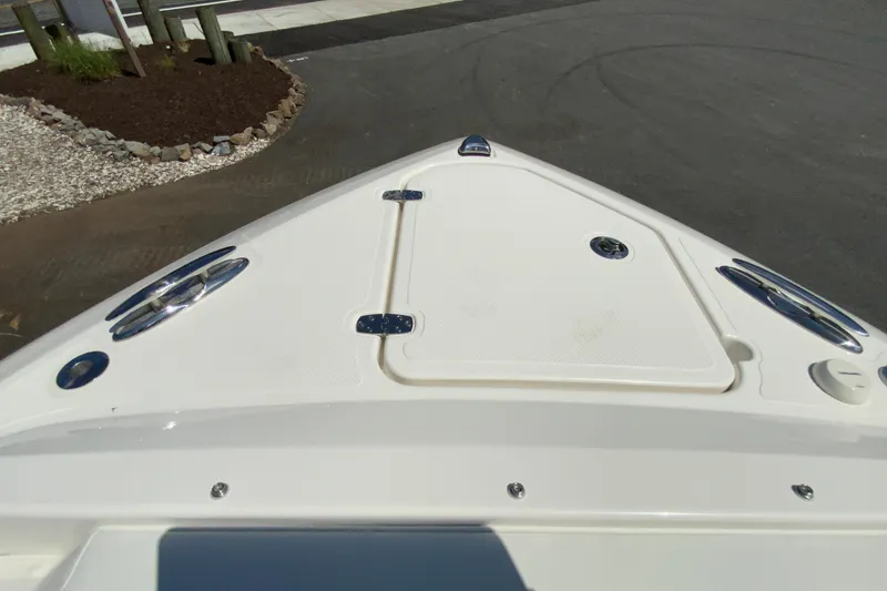 Slide: The Image of Bow of 2026 Pursuit DC 266 Dual Console boat, featuring sleek design and storage hatch. - 37