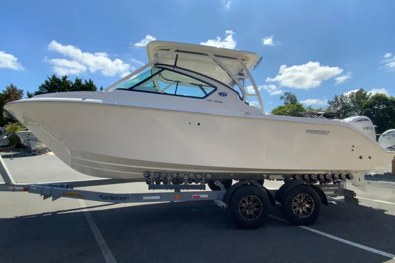 Slide: The Image of 2026 Pursuit DC 266 Dual Console boat on trailer under clear blue sky. - 7