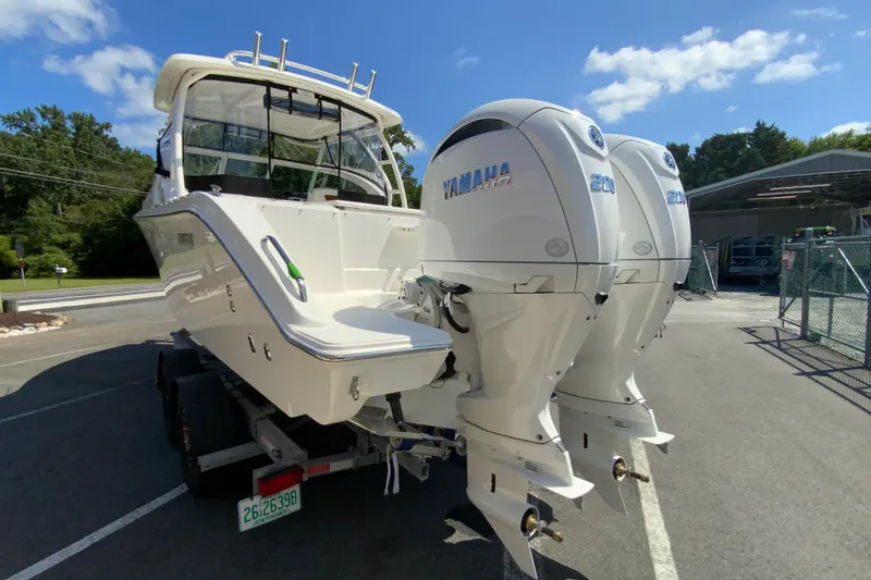 Slide: The Image of 2026 Pursuit DC 266 Dual Console boat with twin Yamaha engines, parked outdoors. - 9