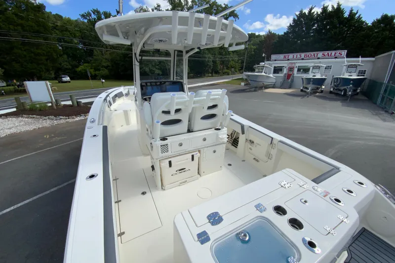 Slide: The Image of 2026 Cobia 265 Open Center Console boat at dealership, showcasing spacious deck and seating. - 11