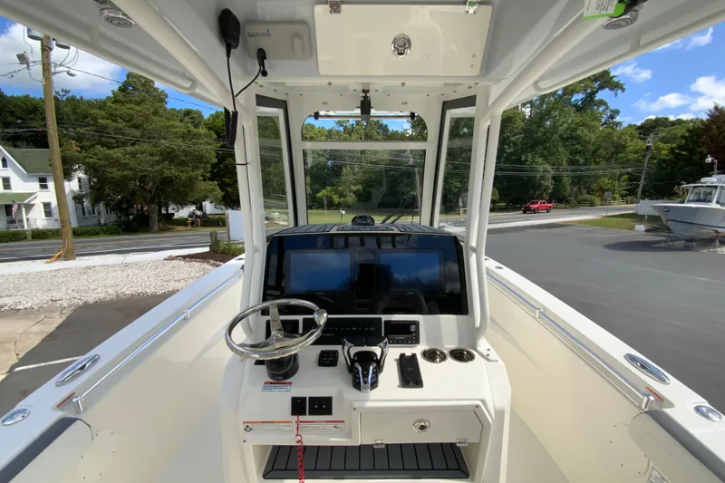 Slide: The Image of 2026 Cobia 265 Open Center Console boat interior with steering wheel and control panel. - 12