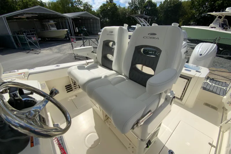 Slide: The Image of 2026 Cobia 265 Open Center Console boat with dual cushioned seats and steering wheel. - 15