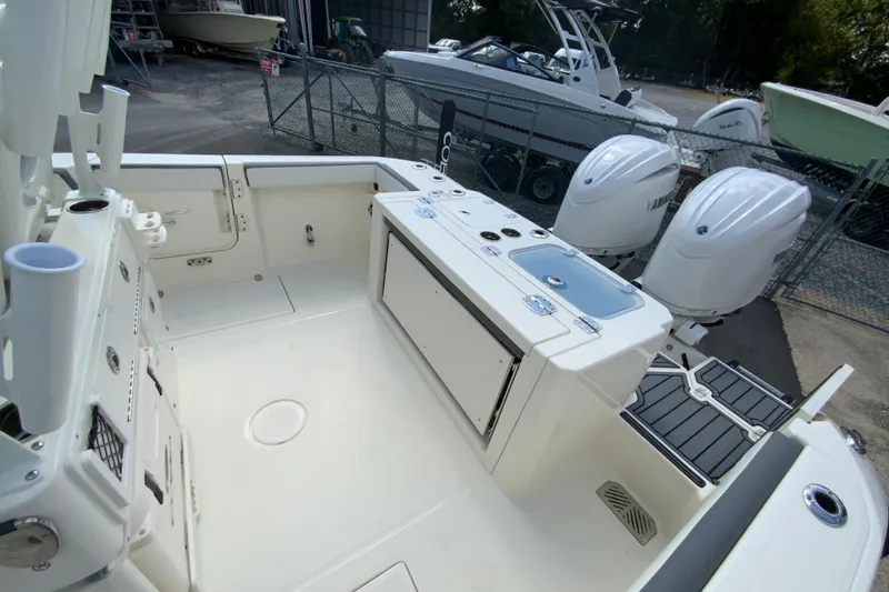 Slide: The Image of 2026 Cobia 265 Open Center Console boat interior with dual outboard engines. - 16