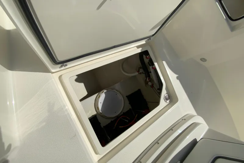 Slide: The Image of 2026 Cobia 265 Open Center Console storage compartment with open hatch. - 25