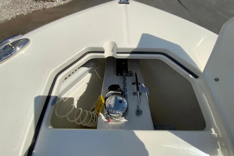 Slide: The Image of 2026 Cobia 265 Open Center Console anchor compartment with chain and winch. - 27