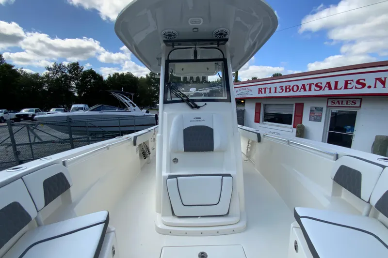 Slide: The Image of 2026 Cobia 265 Open Center Console boat at dealership, showcasing spacious interior design. - 31