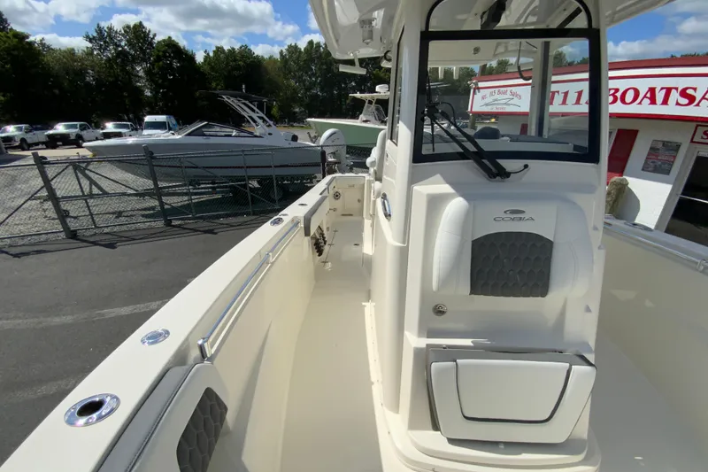 Slide: The Image of 2026 Cobia 265 Open Center Console boat at a dealership, showcasing sleek design. - 35