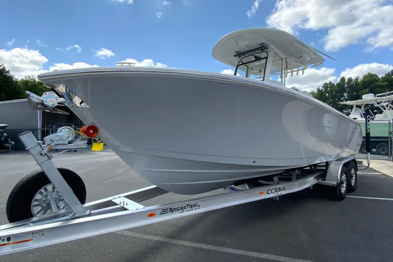 Slide: The Image of 2026 Cobia 265 Open Center Console boat on trailer under blue sky. - 5