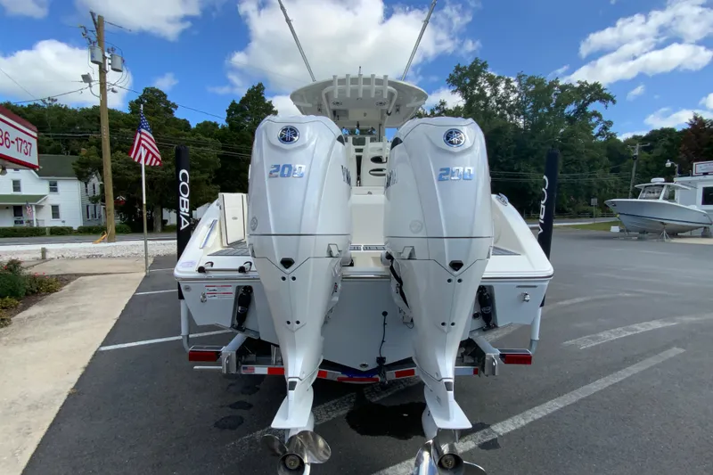 Slide: The Image of 2026 Cobia 265 Open Center Console with twin Yamaha 200 engines, parked outdoors. - 9