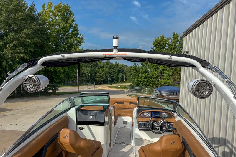 Slide: The Image of 2022 Four Winns HD5 boat interior with brown seating and modern dashboard. - 10
