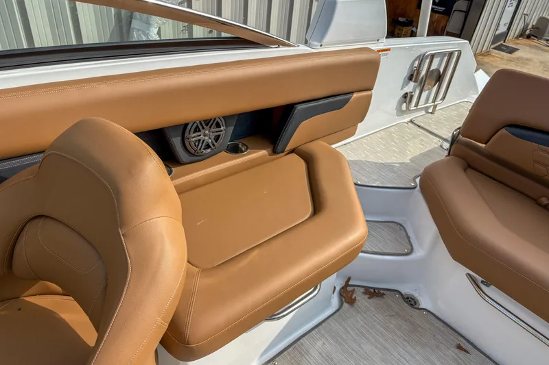 Slide: The Image of 2022 Four Winns HD5 boat interior with tan leather seating and speaker system. - 12
