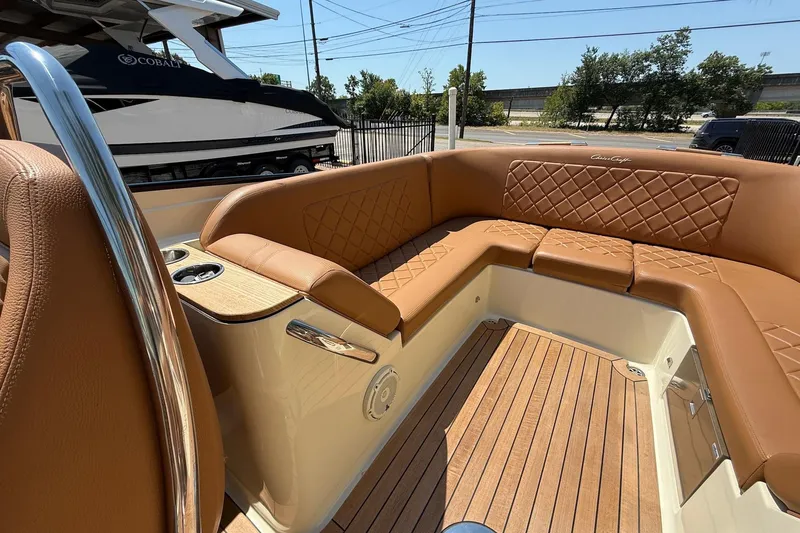 Slide: The Image of 2019 Chris-Craft Corsair 27 boat interior with luxurious tan leather seating and wood flooring. - 14