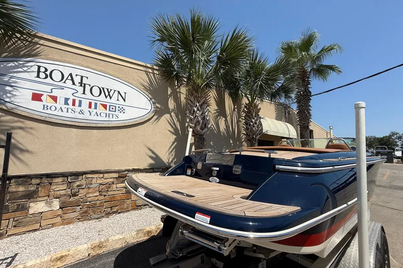 Slide: The Image of 2019 Chris-Craft Corsair 27 boat at Boat Town dealership, surrounded by palm trees. - 5