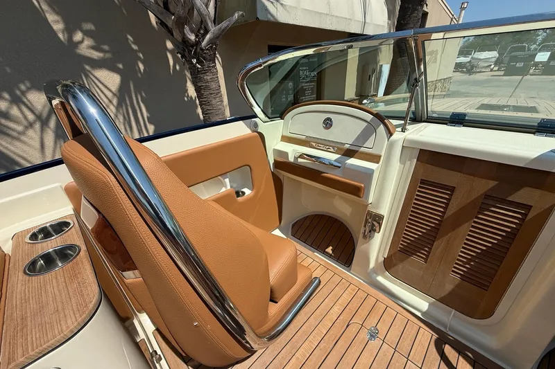 Slide: The Image of 2019 Chris-Craft Corsair 27 interior with tan leather seating and wood accents. - 7