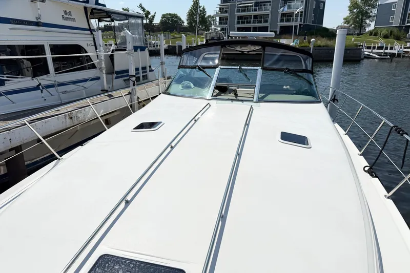 Slide: The Image of 1998 Sea Ray 400 Express Cruiser docked at marina, featuring sleek white deck design. - 1