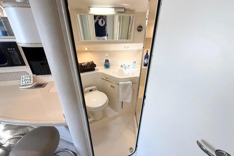 Slide: The Image of 1998 Sea Ray 400 Express Cruiser bathroom interior with sink, toilet, and mirror. - 12