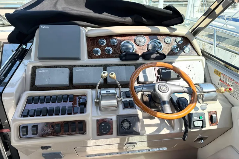 Slide: The Image of 1998 Sea Ray 400 Express Cruiser helm with gauges, controls, and wooden steering wheel. - 2