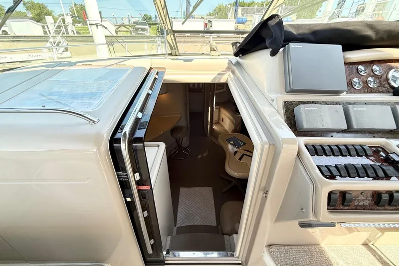Slide: The Image of 1998 Sea Ray 400 Express Cruiser helm with open cabin entrance and control panel. - 3