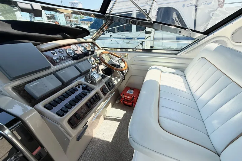 Slide: The Image of 1998 Sea Ray 400 Express Cruiser helm with white seating and control panel. - 4