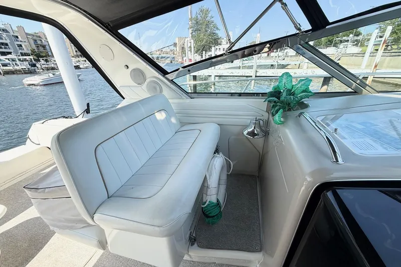 Slide: The Image of 1998 Sea Ray 400 Express Cruiser interior with white seating and marina view. - 8