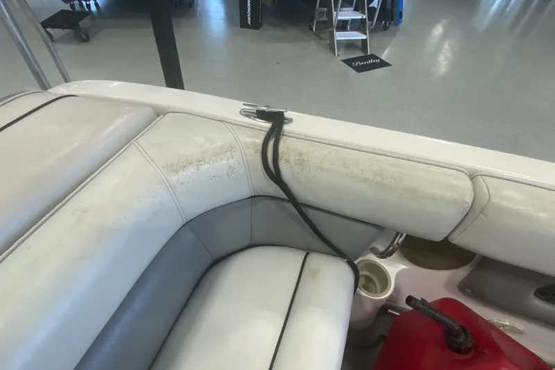 Slide: The Image of 2002 Supra Sunsport boat interior with white seating and visible wear. - 14