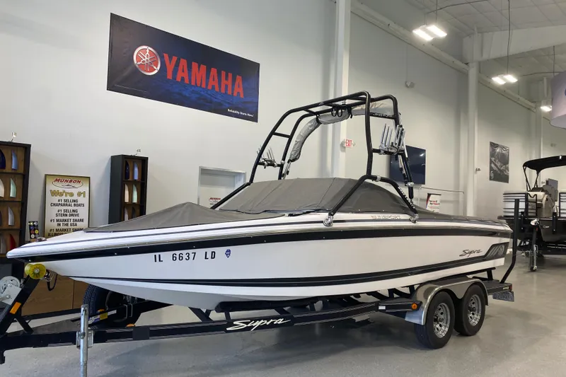 Slide: The Image of 2002 Supra Sunsport 22' boat on trailer in showroom, Yamaha banner above. - 2