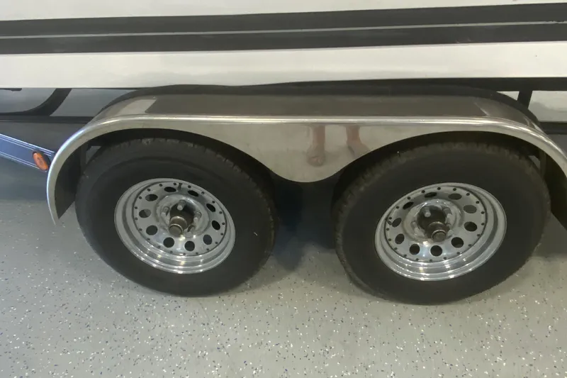 Slide: The Image of Trailer wheels of a 2002 Supra Sunsport 22' boat on a speckled floor. - 4