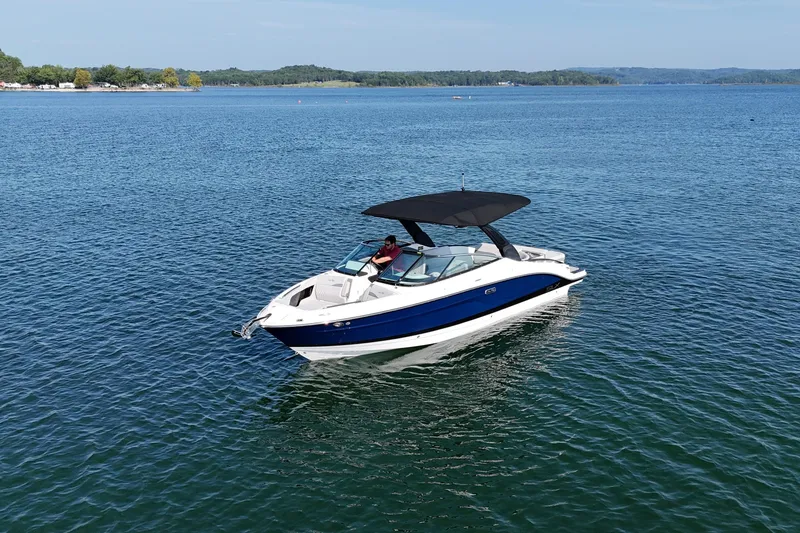 The Image of 2024 Sea Ray SLX 280 boat cruising on a serene lake under clear skies. - 1