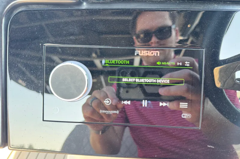 Slide: The Image of 2024 Sea Ray SLX 280 dashboard with Fusion Bluetooth audio system display. - 24