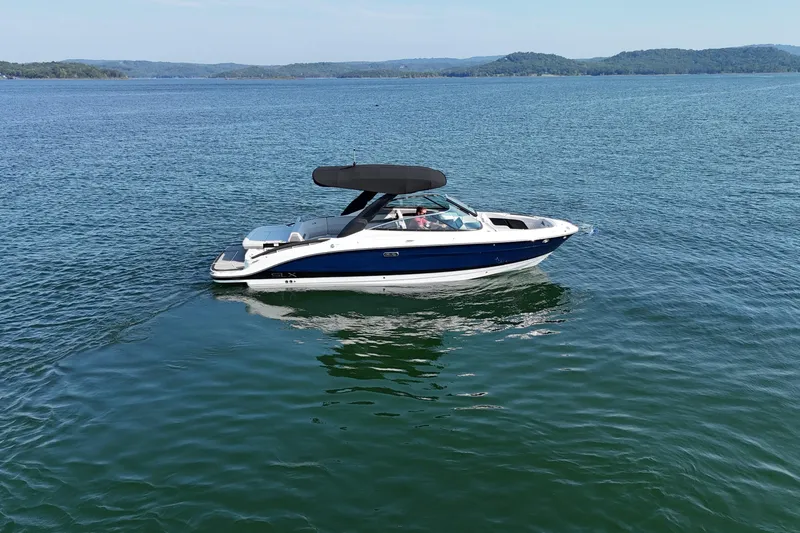 Slide: The Image of 2024 Sea Ray SLX 280 boat cruising on a serene lake with scenic hills. - 5