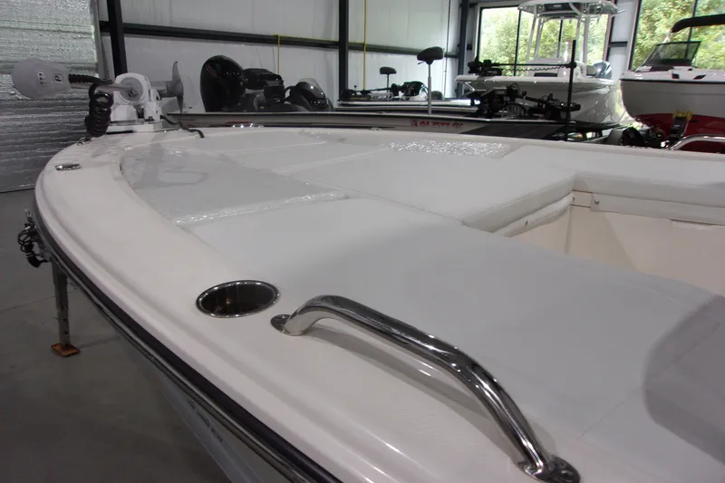 Slide: The Image of 2024 Pathfinder 2200 boat interior with white seating and metal fixtures in a showroom. - 17