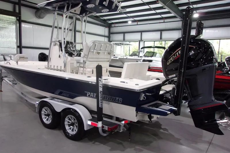 Slide: The Image of 2024 Pathfinder 2200 boat in showroom, featuring sleek design and powerful outboard motor. - 4