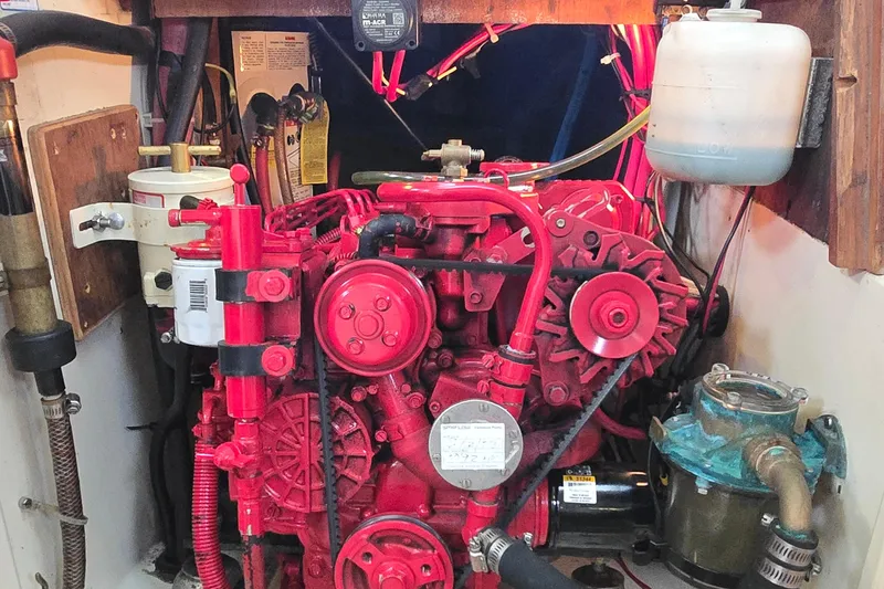 Slide: The Image of Engine compartment of a 1985 Pacific Seacraft 37 sailboat, featuring a red marine engine. - 11