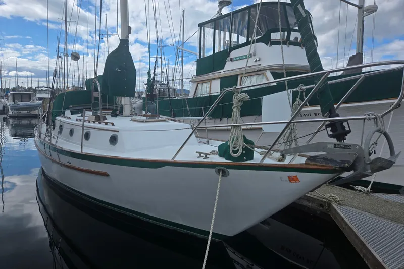 Slide: The Image of 1985 Pacific Seacraft 37 sailboat docked at marina under cloudy sky. - 14