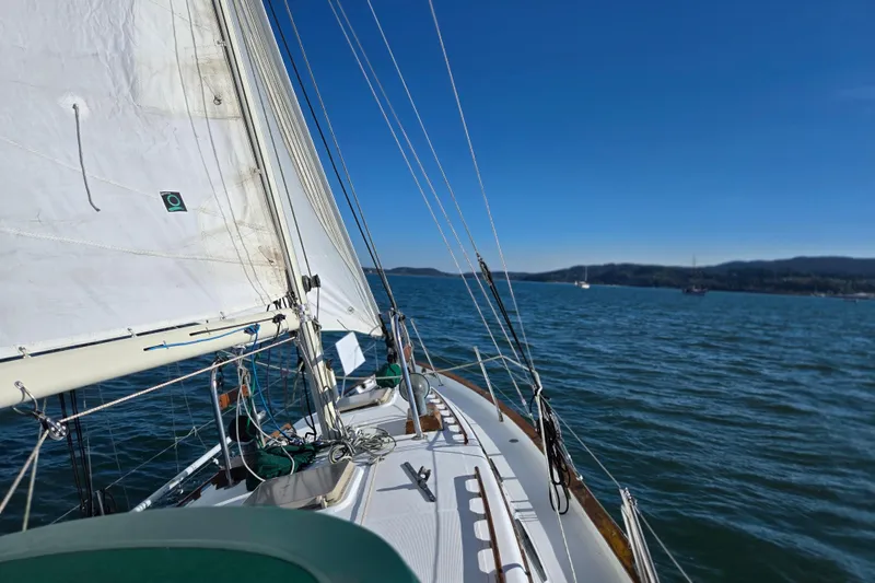 Slide: The Image of 1985 Pacific Seacraft 37 sailboat navigating calm waters under clear blue skies. - 18