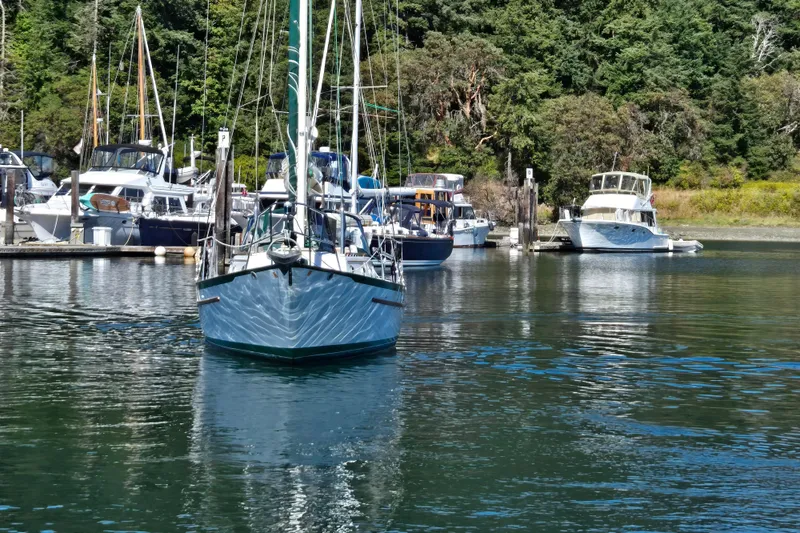 Slide: The Image of Sailboats docked in a serene marina, featuring a 1985 Pacific Seacraft 37. - 2