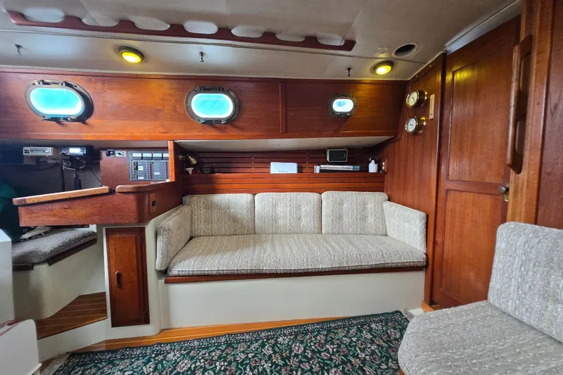 Slide: The Image of Cozy interior of 1985 Pacific Seacraft 37 sailboat with wooden accents and plush seating. - 5
