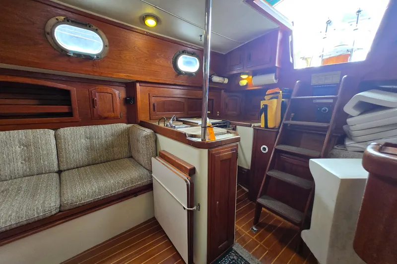 Slide: The Image of Interior of 1985 Pacific Seacraft 37 sailboat with wooden cabinetry and cozy seating area. - 7