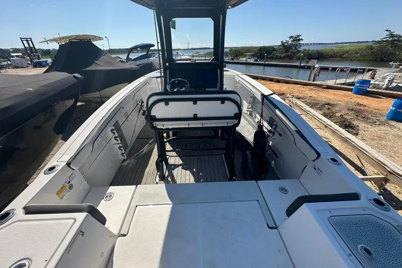 Slide: The Image of 2023 Yamaha Boats 252 FSH Sport interior, docked near a scenic waterfront. - 11