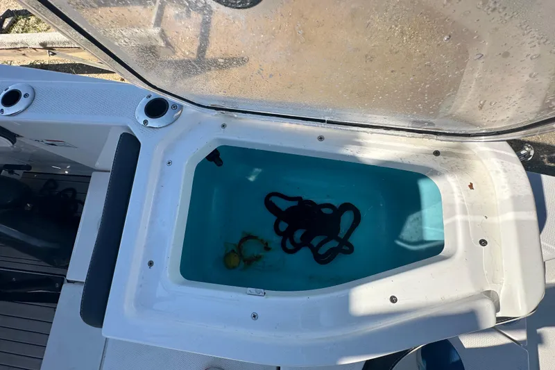 Slide: The Image of 2023 Yamaha Boats 252 FSH Sport livewell with rope and water inside. - 12