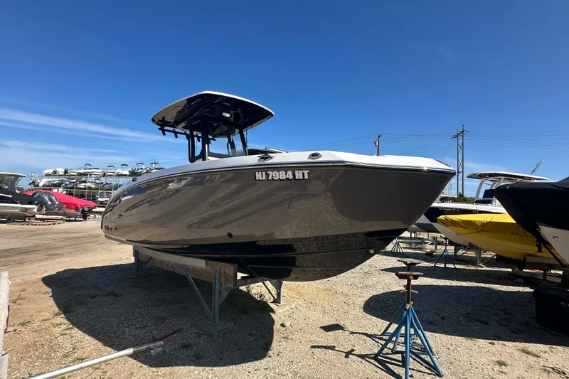Slide: The Image of 2023 Yamaha Boats 252 FSH Sport on display in a boatyard under clear blue skies. - 2